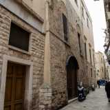 ...e l�adiacente prospetto in pietra del XIII secolo, con finestre e archi centinati, salvato dalla distruzione